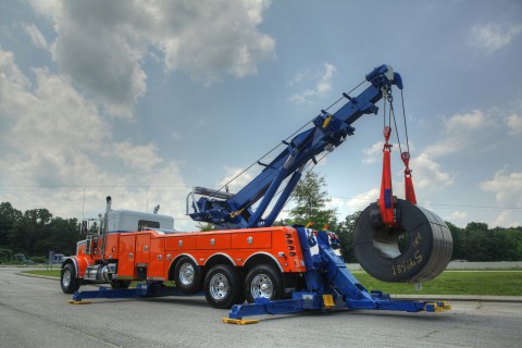 orange white and blue century 1150 rotator lifting a steel coil